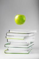 een groen appel zweeft over- isoleren boeken Aan een wit achtergrond. foto