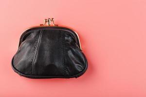klassiek zwart portemonnee Aan een roze achtergrond. minimalistisch concept. foto