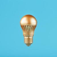 een gouden LED lamp zweeft Aan een blauw achtergrond. concept van een idee met minimalisme. foto