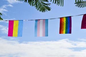 lgbtq vlaggen waren hing Aan draad tegen blauwe lucht Aan zonnig dag, zacht en selectief focus, concept voor lgbtq geslacht vieringen in trots maand in de omgeving van de wereld. foto