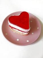 hartvormig aardbei taart Aan een roze bord Aan een wit achtergrond foto