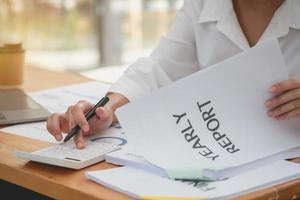 marketing, financiën, boekhouding, planning, vrouw accountant gebruik makend van laptop rekenmachine en documenten, grafieken, grafieken in de analyse van de van het bedrijf winst foto