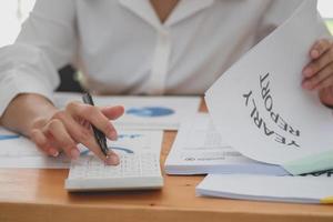 marketing, financiën, boekhouding, planning, vrouw accountant gebruik makend van laptop rekenmachine en documenten, grafieken, grafieken in de analyse van de van het bedrijf winst foto