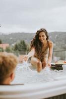 jong paar genieten van in buitenshuis heet kuip Aan vakantie foto