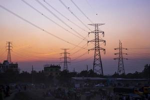 hoog Spanning elektrisch pylonen met kleurrijk landschappen na zonsondergang foto