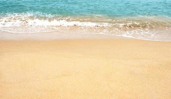 zand strand en blauw oceaan met zacht Golf het formulier Aan zand textuur, kust visie van bruin strand zand duin in zonnig dag lente, holizontaal top visie voor zomer banier achtergrond. foto