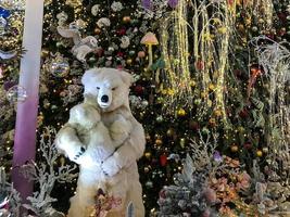Kerstmis decoraties. een speelgoed- polair beer staat De volgende naar een kunstmatig Kerstmis boom. moeder beer houdt haar welp in haar armen. Kerstmis vooravond. gestileerde tentoonstelling voor bezoekers handgemaakt foto