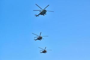 drie militaire helikopters die in de blauwe lucht vliegen en demonstratievlucht uitvoeren, luchtshow, kopieerruimte foto