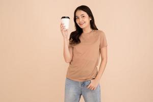 gelukkig jong vrouw Holding koffie kop staand in de studio foto