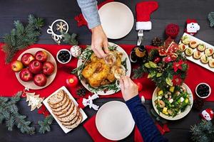 gebakken kalkoen. Kerstmis diner. de Kerstmis tafel is geserveerd met een kalkoen, versierd met helder klatergoud en kaarsen. gebakken kip, tafel. familie diner. top visie foto