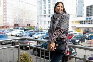 portret van een jong gelukkig vrouw Aan de achtergrond van de stad met een glimlach Aan haar gezicht foto