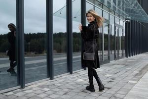 portret van een vrouw kantoor arbeider tegen de backdrop van een glas wolkenkrabber foto