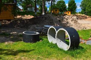 groot ronde beton cement steen ringen voor de bouw van riolering putten gedurende de bouw van de huis foto