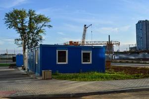 elektrisch huis met macht lijnen. huis met lucht conditioning voor elektriciteit schilden met ramen. tegen de backdrop van de bouw van een nieuw woon- complex en bouw uitrusting foto