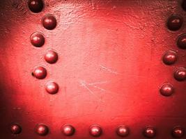 rood ijzer metaal ruw geschilderd sterk solide industrieel muur met klinknagel gaten en bouten. achtergrond, structuur foto