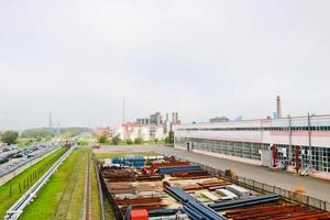 industrieel landschap. panoramisch visie van de technologisch pijpen. roestig pijpen, blauw robijnen, productie communicatie. reparatie gebouwen in productie. tegen de achtergrond van een nevelig lucht foto