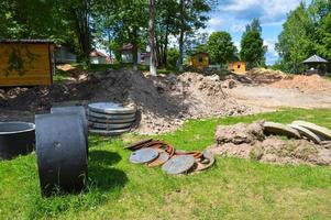groot ronde beton cement steen ringen voor de bouw van riolering putten gedurende de bouw van de huis foto