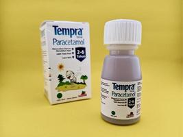 malang, Indonesië - oktober 22, 2022 - paracetamol siroop met merk tempra. siroop flessen en karton verpakking met geïsoleerd geel achtergrond foto