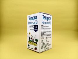 malang, Indonesië - oktober 22, 2022 - paracetamol siroop met merk tempra. siroop flessen en karton verpakking met geïsoleerd geel achtergrond foto