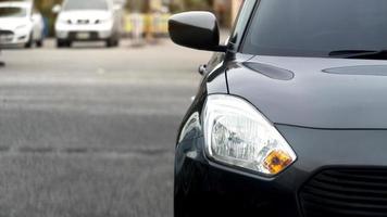 voorkant van zwart auto Aan de weg met wazig van andere auto's in de terug foto