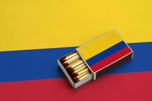 Colombia vlag is getoond in een Open luciferdoosje, welke is gevulde met wedstrijden en leugens Aan een groot vlag foto