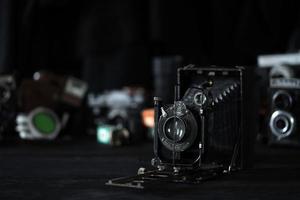 Charkov, Oekraïne - april 27, 2021 fotokor-1 film foto camera en een ander oud retro foto uitrusting Aan zwart houten tafel in fotograaf donkere kamer. fotografisch uitrusting van Sovjet unie
