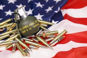 m67 frag granaat en veel geel kogels en inktpatronen Aan Verenigde staten vlag. concept van geweer mensenhandel Aan Verenigde Staten van Amerika gebied of specificaties ops foto