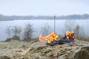 brandend sport- sportschoenen of Sportschool schoenen Aan brand staan Aan zanderig strand kust. atleet verbrand uit. fysiek inspanning gedurende opleiding concept foto