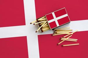 Denemarken vlag is getoond Aan een Open luciferdoosje, van welke meerdere wedstrijden vallen en leugens Aan een groot vlag foto
