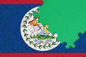 Belize vlag is afgebeeld Aan een voltooid decoupeerzaag puzzel met vrij groen kopiëren ruimte Aan de Rechtsaf kant foto