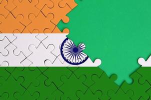 Indië vlag is afgebeeld Aan een voltooid decoupeerzaag puzzel met vrij groen kopiëren ruimte Aan de Rechtsaf kant foto