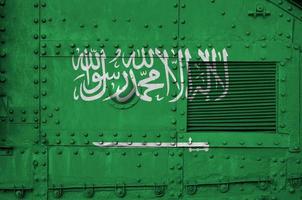 saudi Arabië vlag afgebeeld Aan kant een deel van leger gepantserd tank detailopname. leger krachten conceptuele achtergrond foto