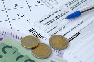 Duitse belasting het formulier met pen en Europese geld rekeningen leugens Aan kantoor kalender. belastingbetalers in Duitsland gebruik makend van euro valuta naar betalen belastingen foto