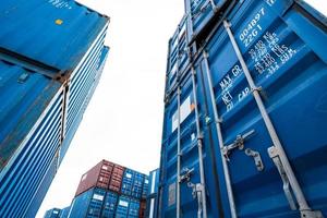 blauwe en rode logistieke container tegen witte lucht. vracht- en scheepvaartbedrijf. containerschip voor import en export logistiek. logistieke branche. container voor vrachtwagenvervoer en luchtlogistiek. foto