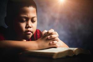 aanbidden christen met Bijbel concept. jong jongen persoon hand- Holding heilig Bijbel met studie Bij huis. volwassen vrouw christen lezing boek in kerk. jongen aan het leren religie geestelijkheid en bidden naar god. foto