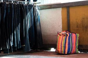 multi kleur Aan plastic zak en de rij van denim broek hangende Aan trilt van vlo markt foto