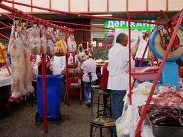 almatië, kazachstan, 2019 - mensen in de vlees sectie van de beroemd groen bazaar van almatië, kazachstan, met goederen Aan Scherm. foto