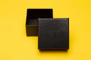 mini zwarte doos geïsoleerd op gele achtergrond foto