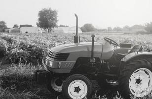 een leeg trekker staat Aan een boer veld. zwart en wit. boerderij machinerie en apparatuur. landbouw industrie foto