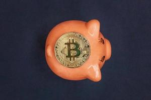 varkentje bank en gouden bitcoin munt virtueel geld Aan zwart achtergrond. cryptogeld en besparing concept. elektronisch virtueel geld voor web bank en Internationale netwerk betaling foto