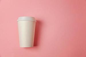 eenvoudig vlak leggen ontwerp papier koffie kop Aan roze pastel kleurrijk modieus achtergrond. meenemen drinken container. mooi zo ochtend- wakker worden omhoog wakker concept. sjabloon van drinken model. top visie kopiëren ruimte. foto