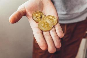 Mens hand- Holding cryptogeld gouden bitcoin munt. elektronisch virtueel geld voor web bank en Internationale netwerk betaling. symbool van crypto virtueel munteenheid. mijnbouw concept. foto