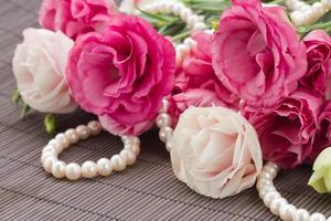 roze eustomabloemen en parelsgrens foto