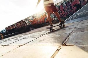 Aan de Actie. detailopname van modern jong Mens skateboarden terwijl hangende uit Bij de vleet park buitenshuis foto