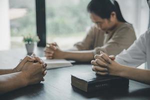 jong vrouw bidden tussen andere religieus bidden tussen, mensen binnenshuis. religieus overtuigingen christen leven crisis gebed naar god. foto