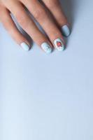 vrouw handen met winter sneeuw manicure met stickers onder een matte top foto