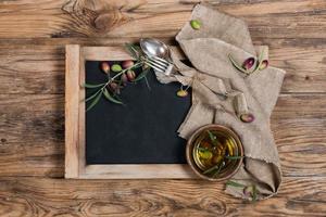 bovenaanzicht van olijfolie met olijftakje en servet foto