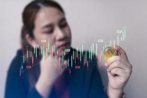 bedrijf vrouw in hand- bitcoin munten met crypto handel grafiek. cryptogeld aandelenbeurs. technologie en investering digitaal concept. financiën, handelaar, investeerder, goud bitcoin contant geld foto
