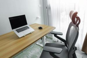 ergonomisch stoel en verstelbaar tafel met laptop computer in modern werkplek. mooi zo houding naar vermijden kantoor syndroom, terug pijn, schouder pijn, fibromyalgie en nek pijn foto