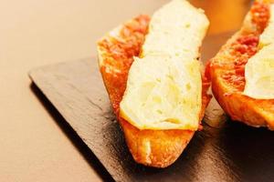 aardappel omelet vleespen met brood met tomaat. typisch Spaans voedsel. horizontaal afbeelding. foto